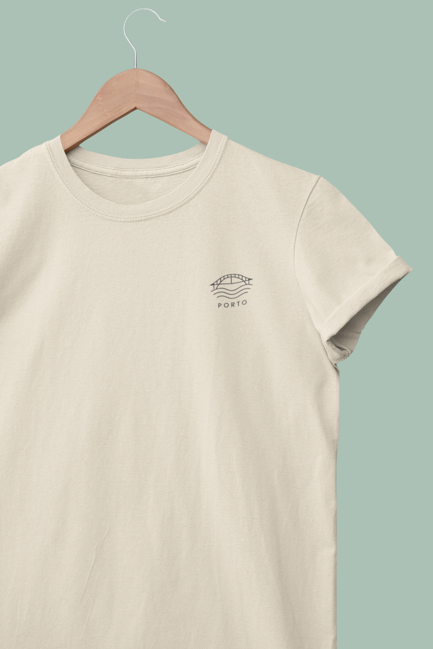 Beige t-shirt with a logo on a hanger against a light green background