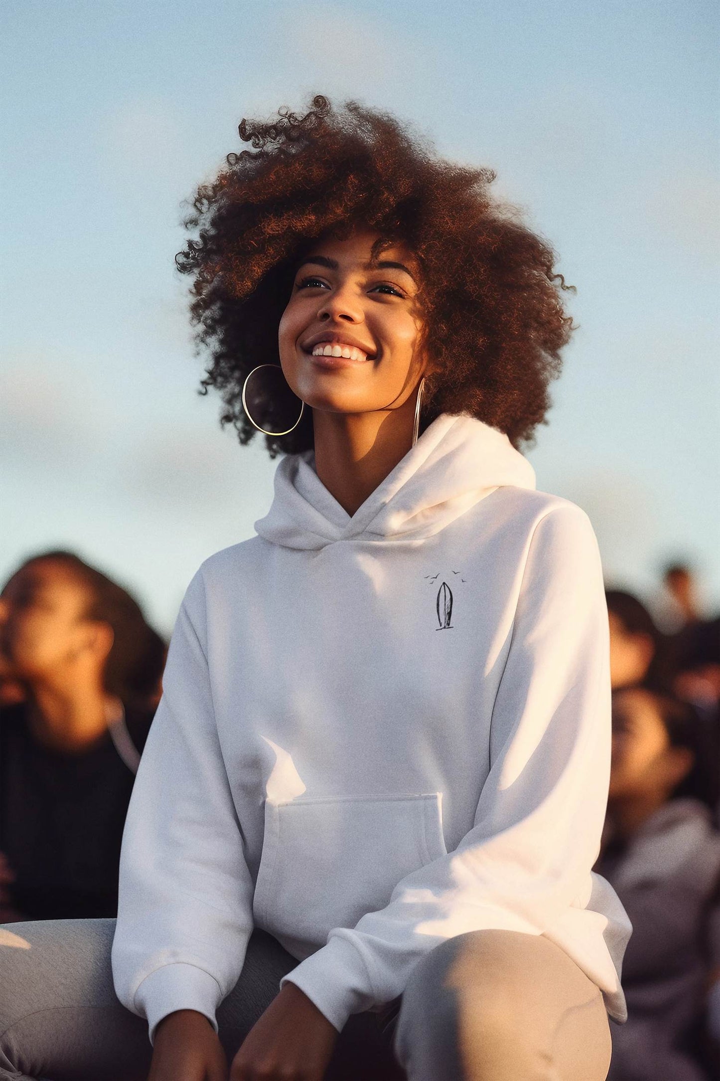 White Ericeira Surf Hoodie worn outdoors with a bright smile. Ethically made, organic, and perfect for casual and surf-inspired fashion.