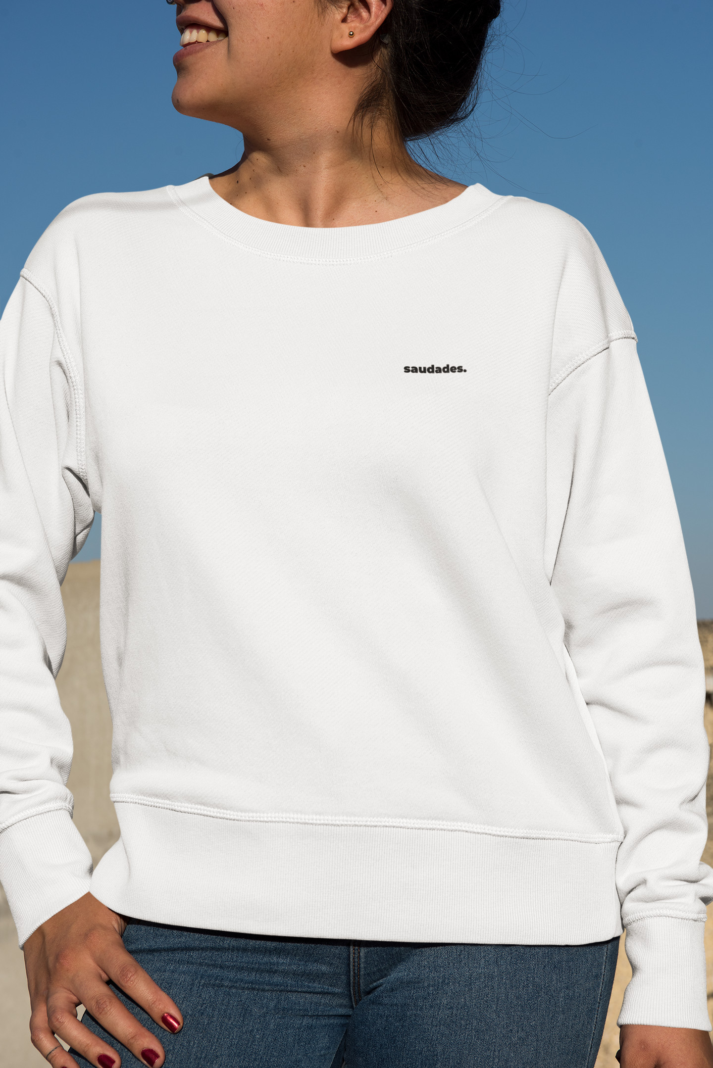 Unisex Saudade sweatshirt flat on neutral background with clean surf style design