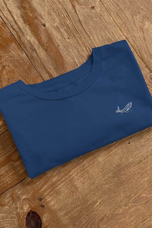 Folded navy blue sardine t-shirt with minimalist embroidered fish design on a wooden surface. Made from organic cotton for comfort and sustainability.