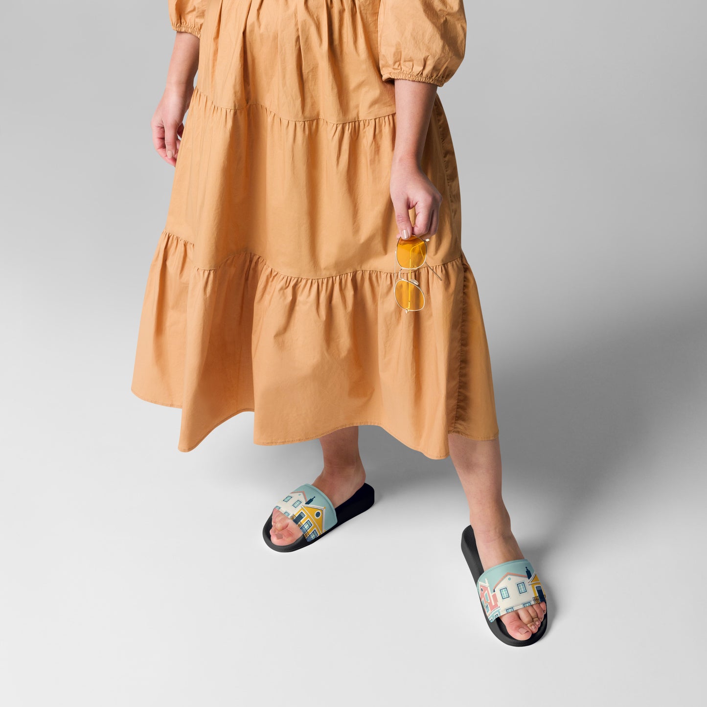 Model in a flowing dress wearing Alfama Woman Pool Slippers with a vibrant Portuguese house design. Perfect for casual and summer wear.