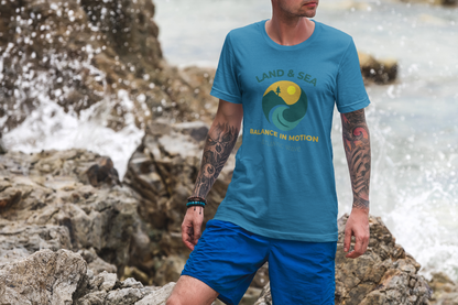 Men’s organic blue t-shirt with “Land & Sea Balance in Motion” graphic, Portugal-inspired design, casual gift idea.