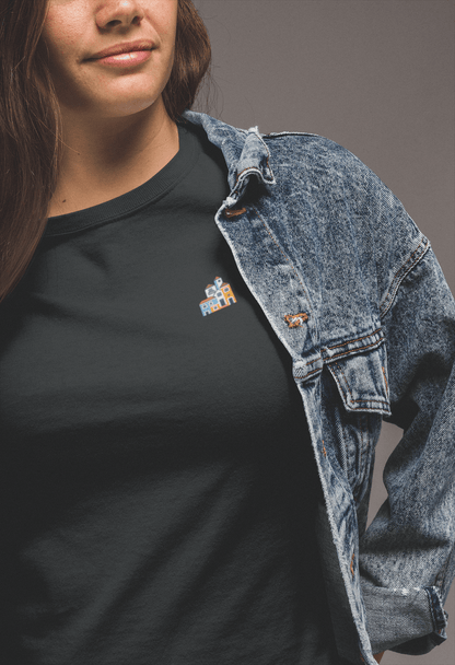 Woman in a black Minimal Alfama Houses Unisex T-Shirt with a denim jacket, featuring a small Lisbon-inspired house design on organic cotton.