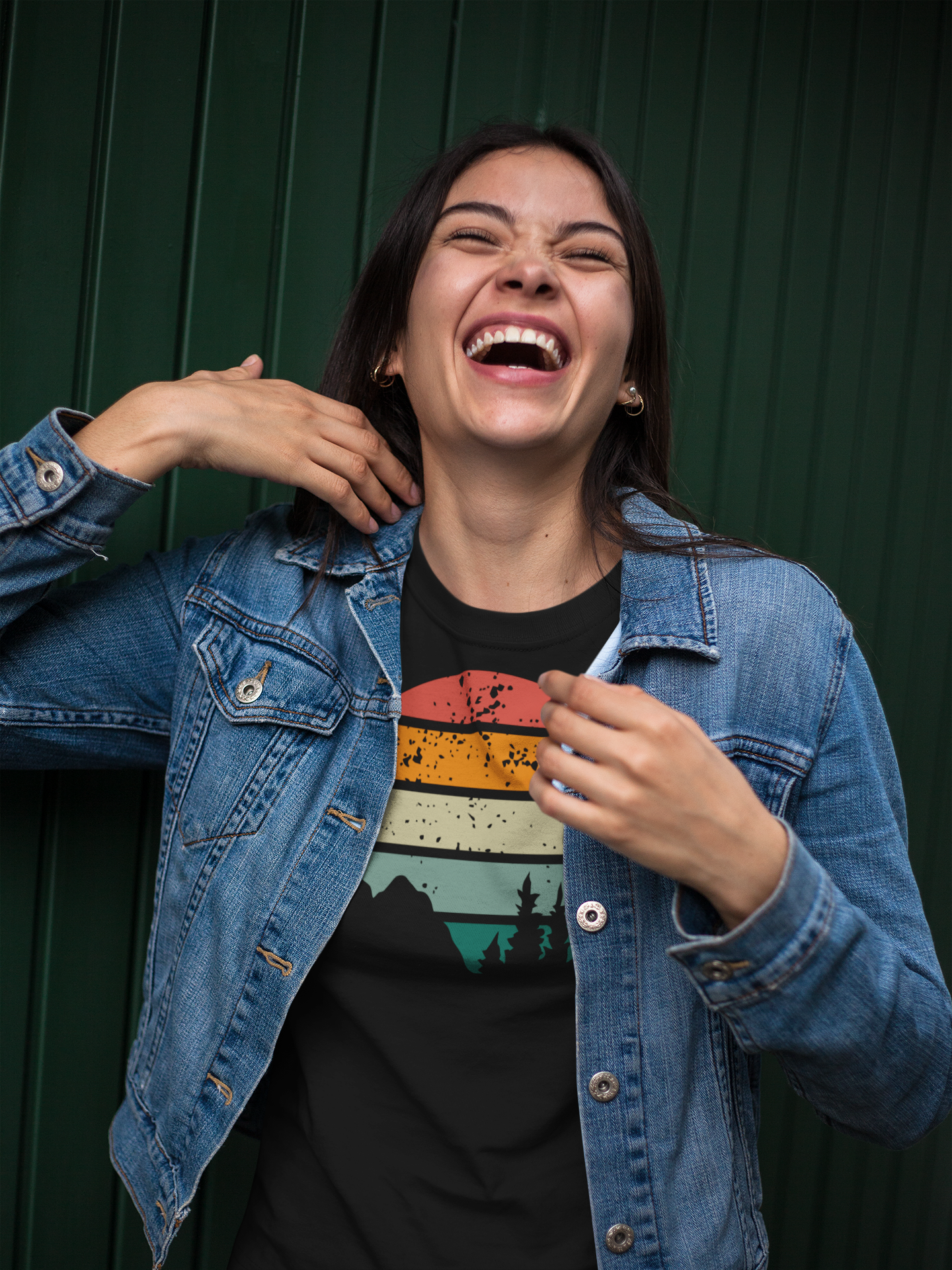 Laughing woman in a black Madeira Mountains Retro Organic Vintage T-Shirt and denim jacket. A fun and casual hiking tee for outdoor lovers.