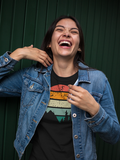 Laughing woman in a black Madeira Mountains Retro Organic Vintage T-Shirt and denim jacket. A fun and casual hiking tee for outdoor lovers.