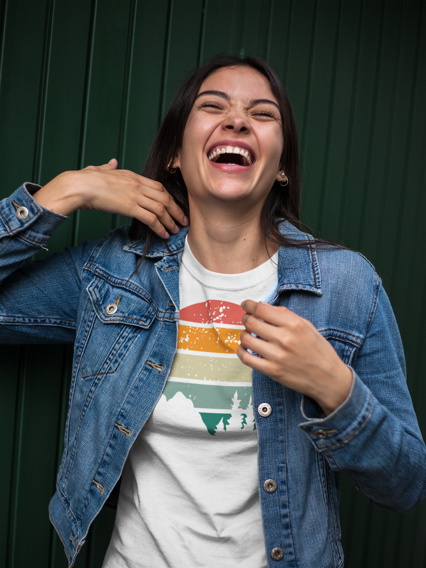 Laughing woman in a white Madeira Mountains Retro Organic Vintage T-Shirt and denim jacket. A stylish and comfortable hiking tee.