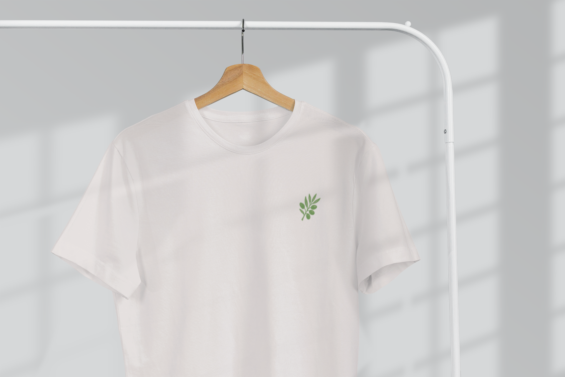 Unisex t-shirt with minimal olive branch logo on chest.