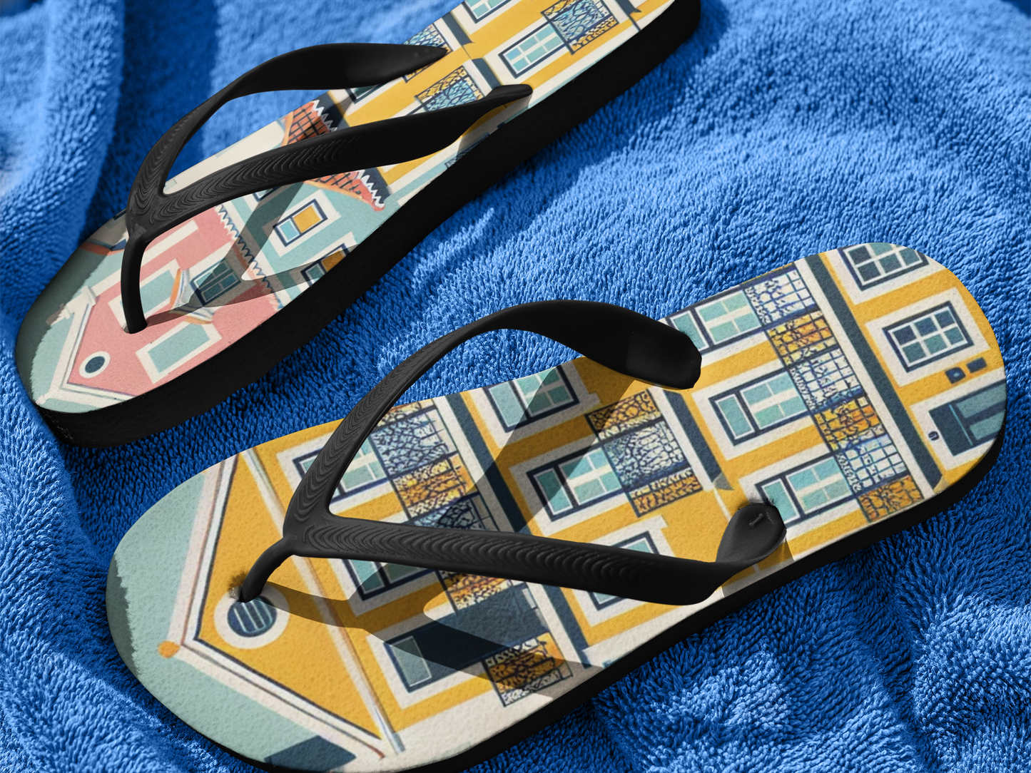 Close-up of Alfama Collection flip flops with Lisbon-inspired design on a blue towel, highlighting their colorful and durable construction.
