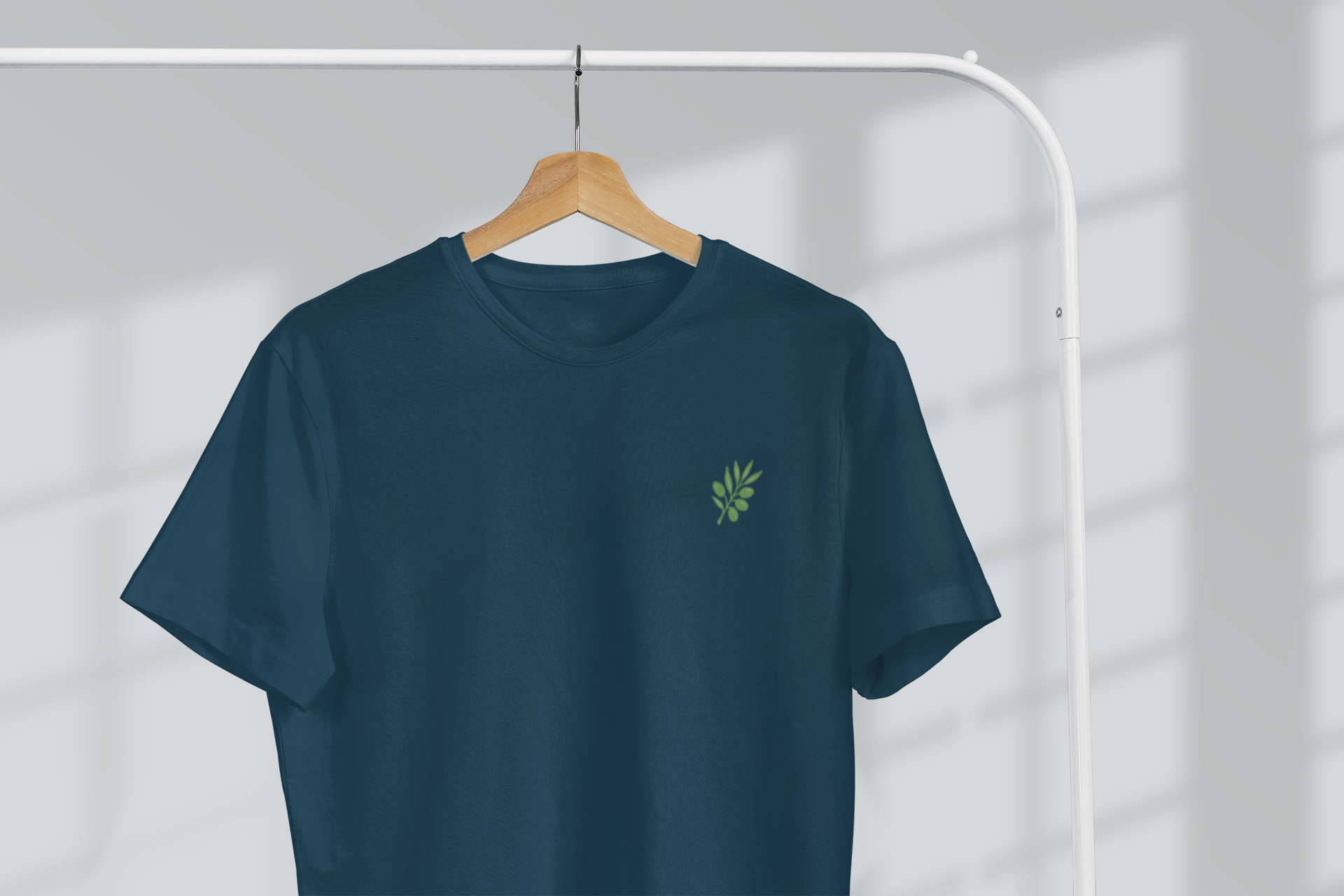 Navy blue t-shirt with a green logo on a hanger against a white background