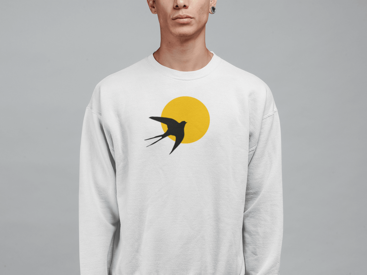 White unisex organic sweater featuring a minimal Andorinha swallow logo with a yellow sun, made from soft organic cotton for a sustainable wardrobe choice.