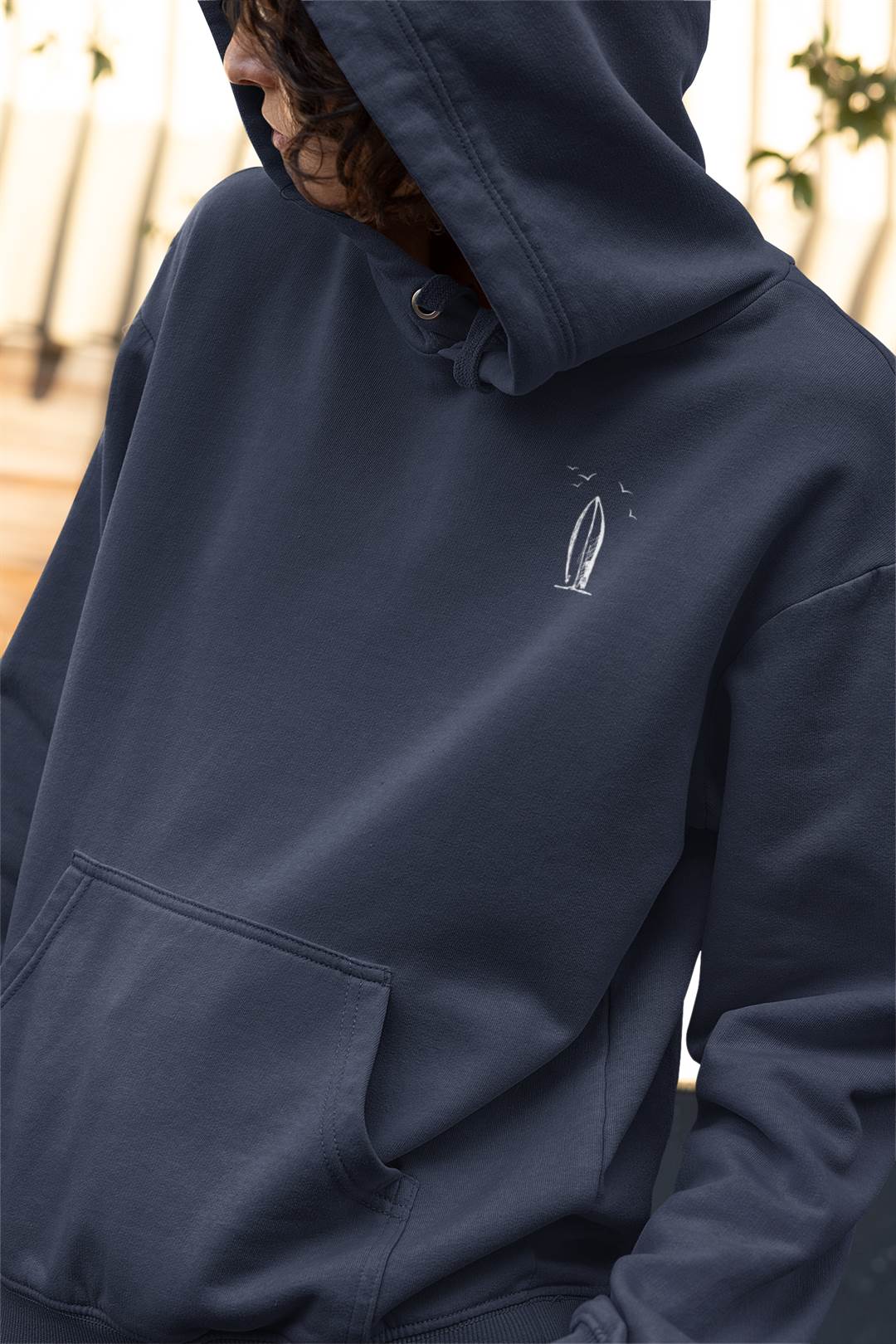 Navy blue Ericeira Surf Hoodie with a subtle surfboard print. Made from organic cotton for a sustainable and stylish surf-inspired look.