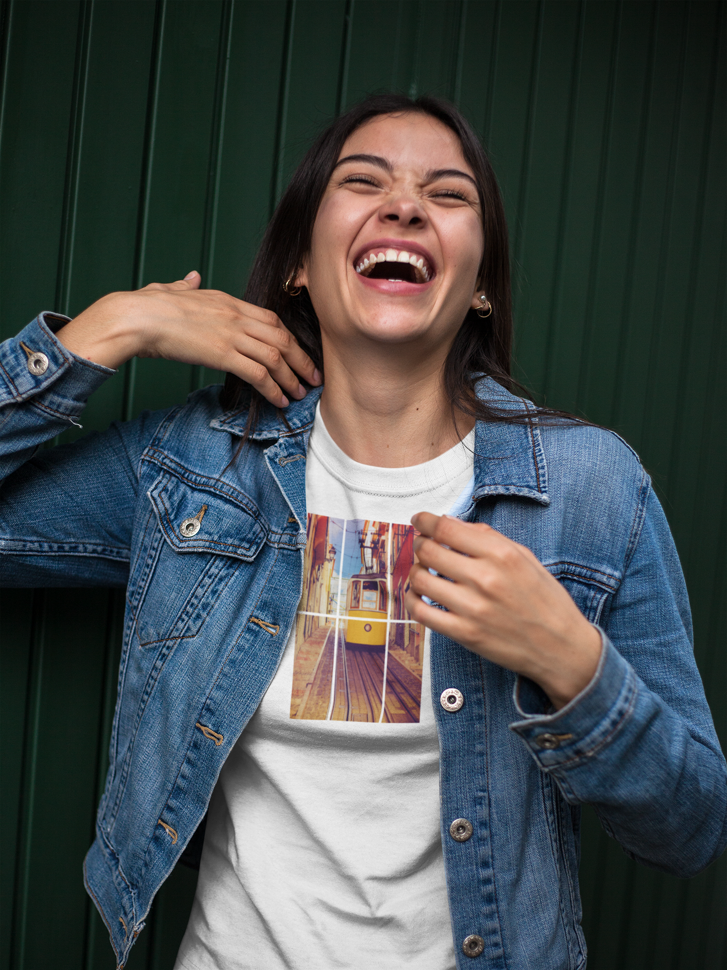 Laughing woman wearing a Lisbon Tram T-shirt with a denim jacket. Organic and sustainable fabric ensures comfort and eco-conscious fashion.