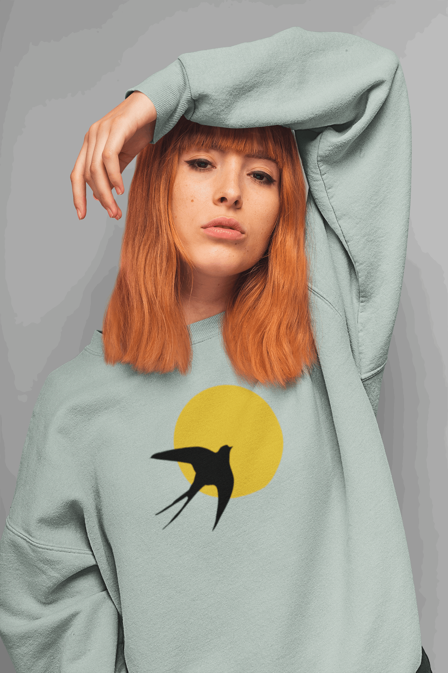 Pastel green unisex organic sweater with a minimal Andorinha swallow logo and yellow sun, made from soft organic cotton for a stylish eco-friendly look.