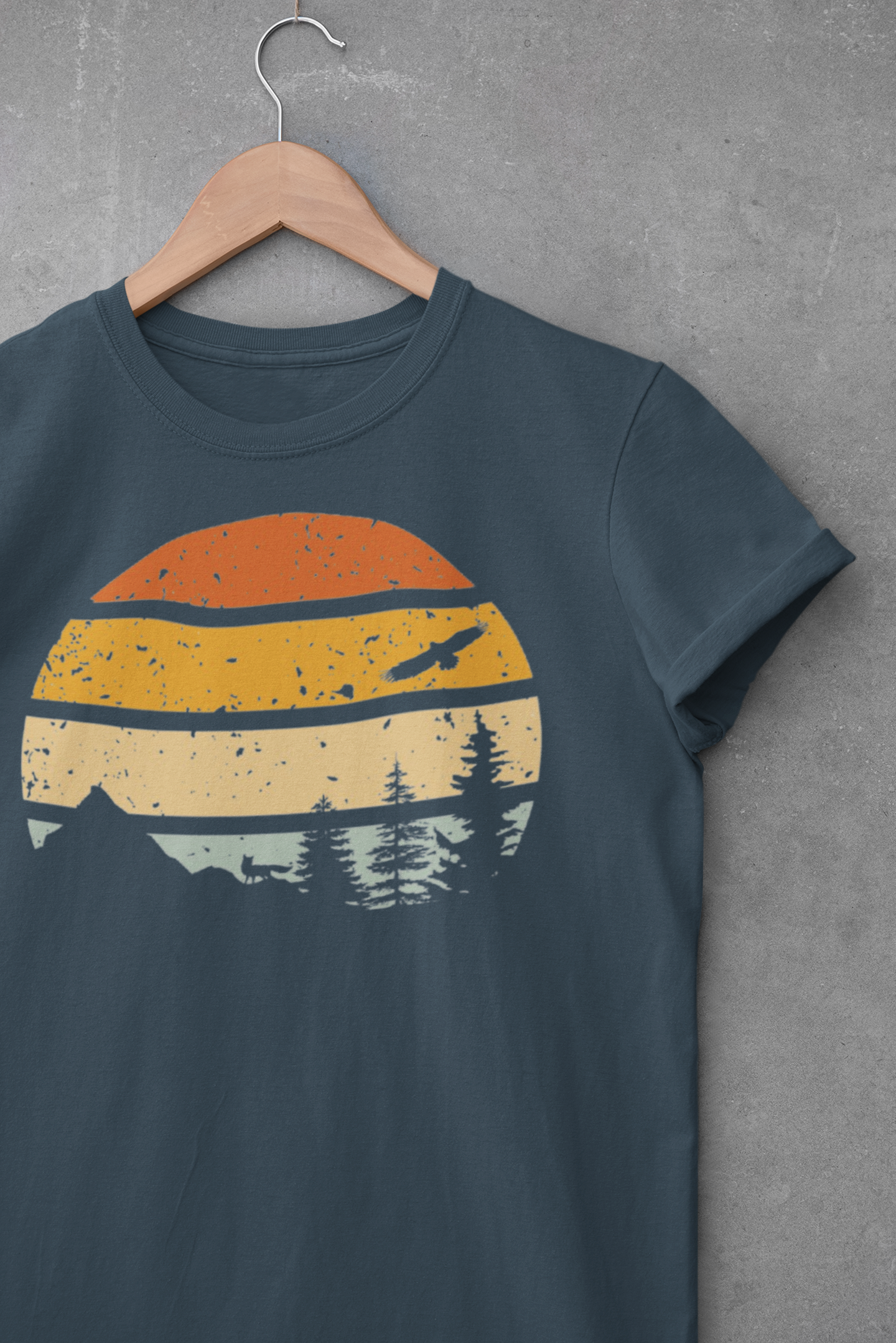 Teal Madeira Mountains Retro Organic Vintage T-Shirt displayed on a hanger. A perfect hiking tee with a retro mountain design.