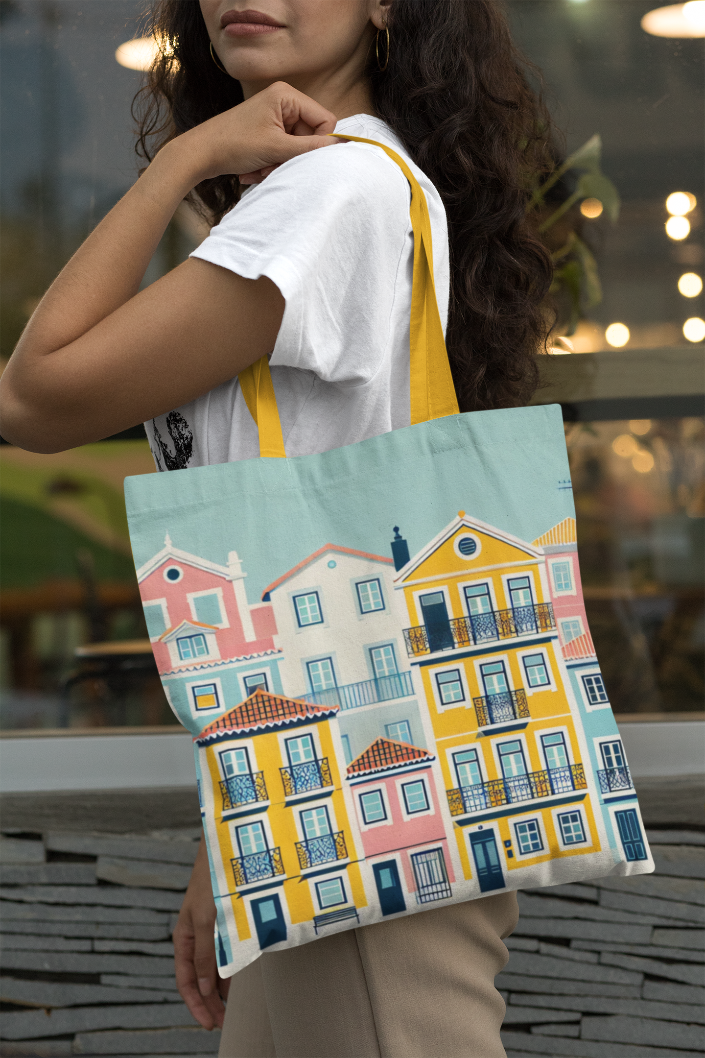 Woman wearing a white t-shirt carrying the Lisbon Tote Bag from the Alfama Collection. A trendy and spacious tote for daily essentials.