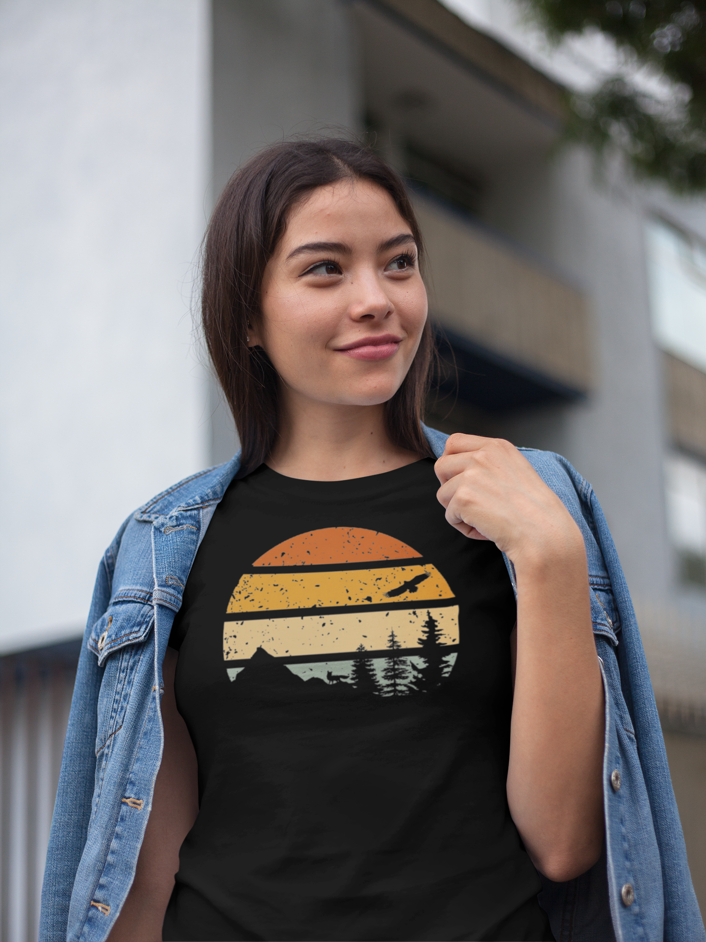 Young woman in a black Madeira Mountains Retro Organic Vintage T-Shirt, styled with a denim jacket. A trendy hiking tee for outdoor lovers.