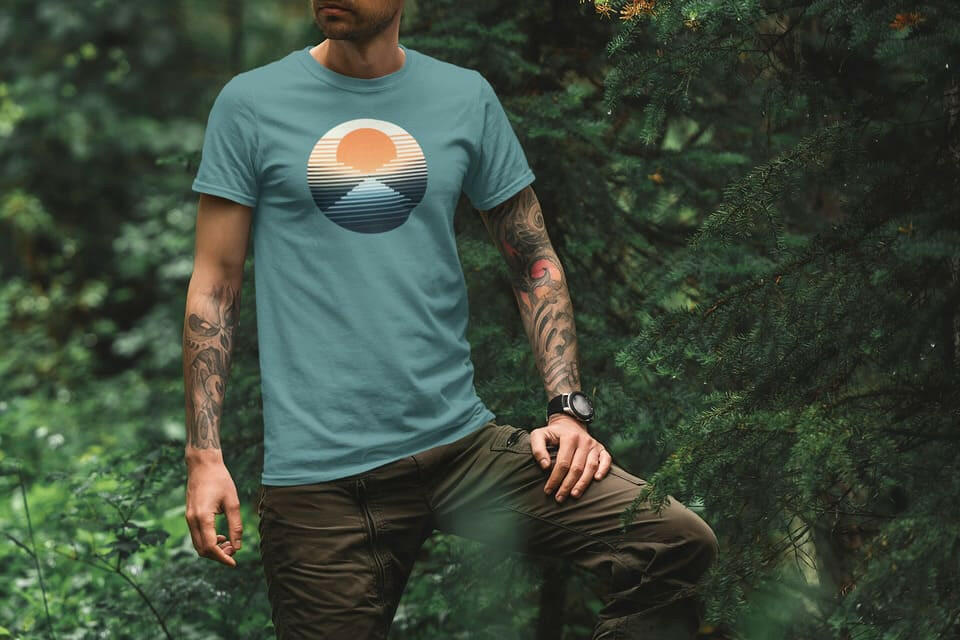 Teal Organic Surf Nazaré T-Shirt with a retro sunset and wave graphic. Made from organic cotton, ideal for outdoor and beachwear.
