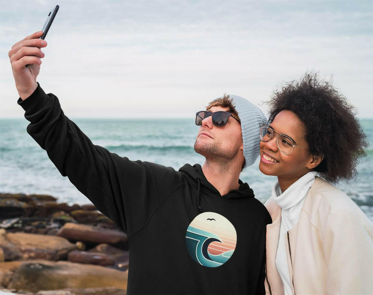 Black Nazaré Surf Wave Hoodie with a retro wave print. Unisex organic hoodie perfect for cool beach days and casual outings.