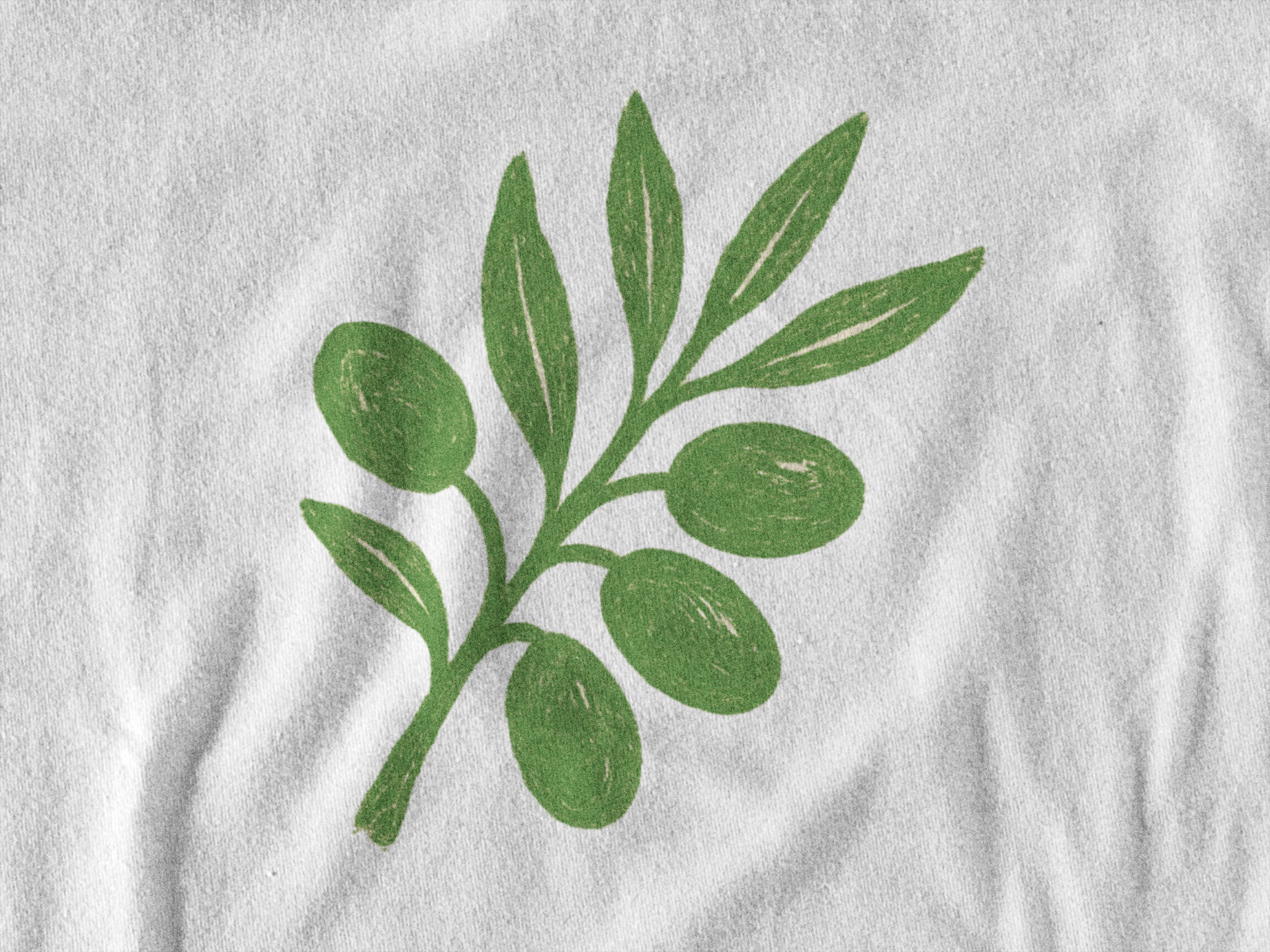 Green olive branch design on a white fabric background