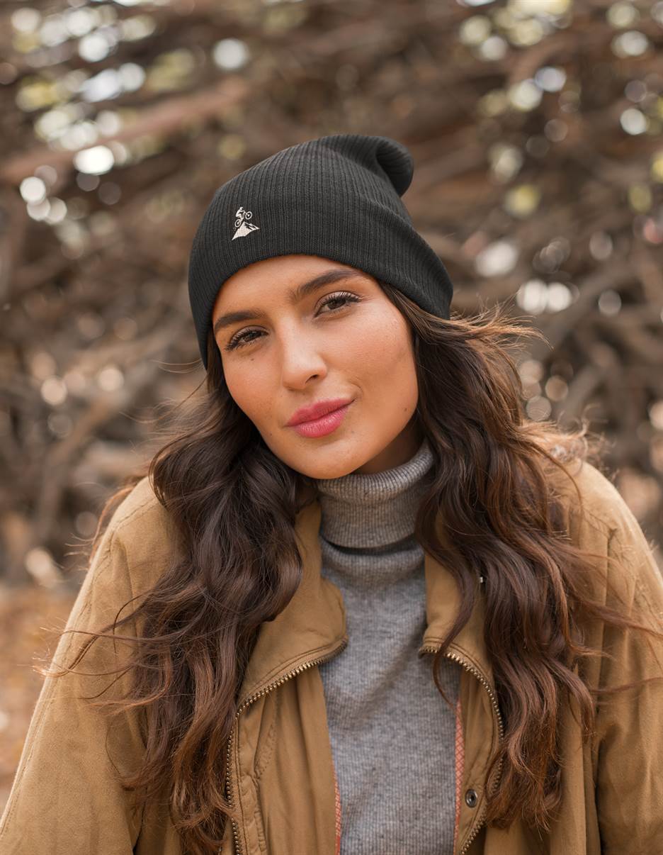 Black Madeira Beanie with embroidered mountain bike logo, worn by a woman outdoors. A cozy and stylish choice for biking enthusiasts.