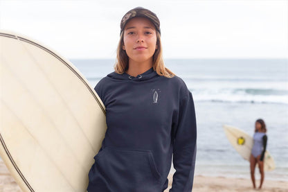 Navy blue Ericeira Surf Hoodie worn by a surfer on the beach. Ethically made, organic, and designed for comfort and style.