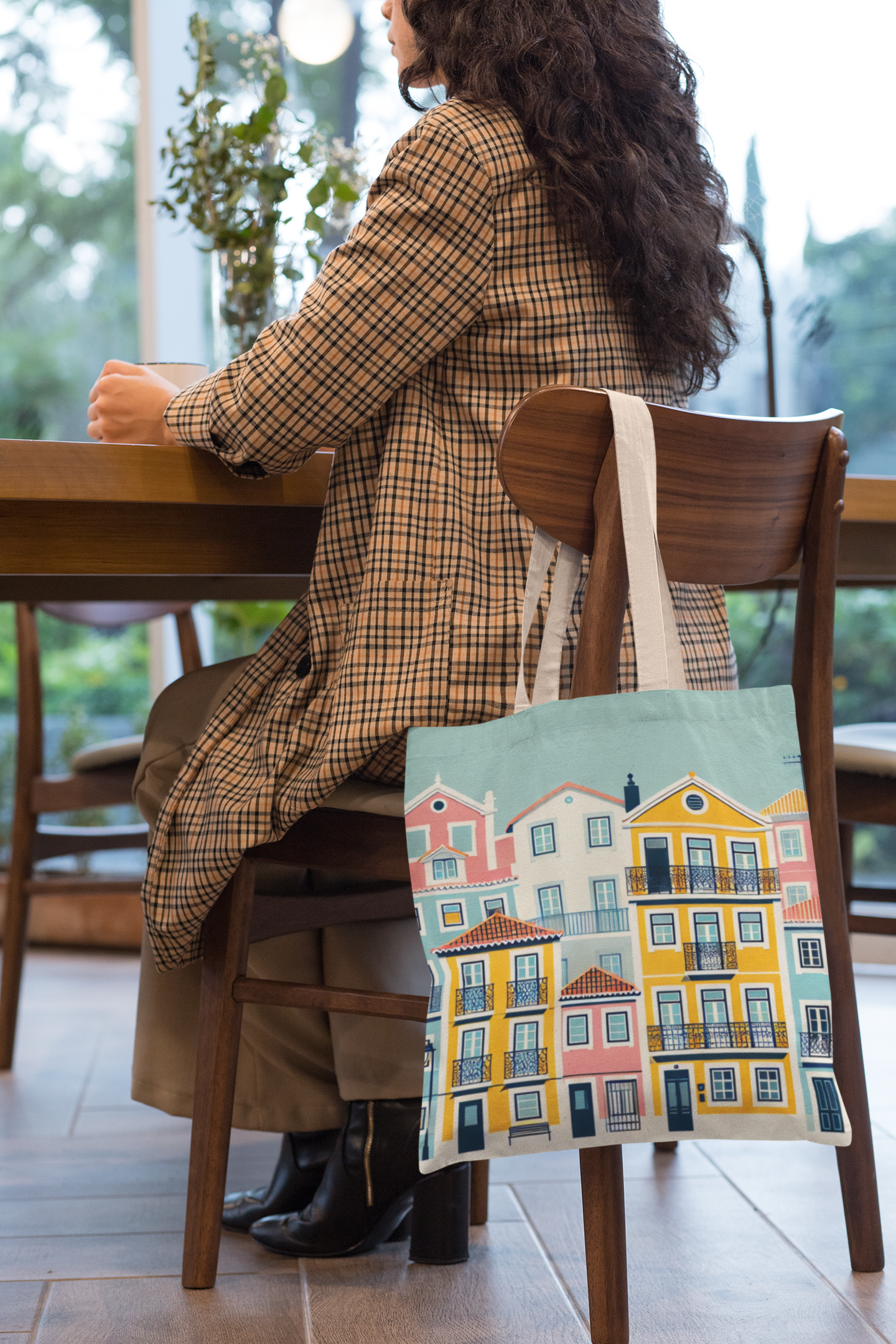 Lisbon Tote Bag from the Alfama Collection hanging on a chair in a cozy café. A stylish and practical accessory for everyday use.