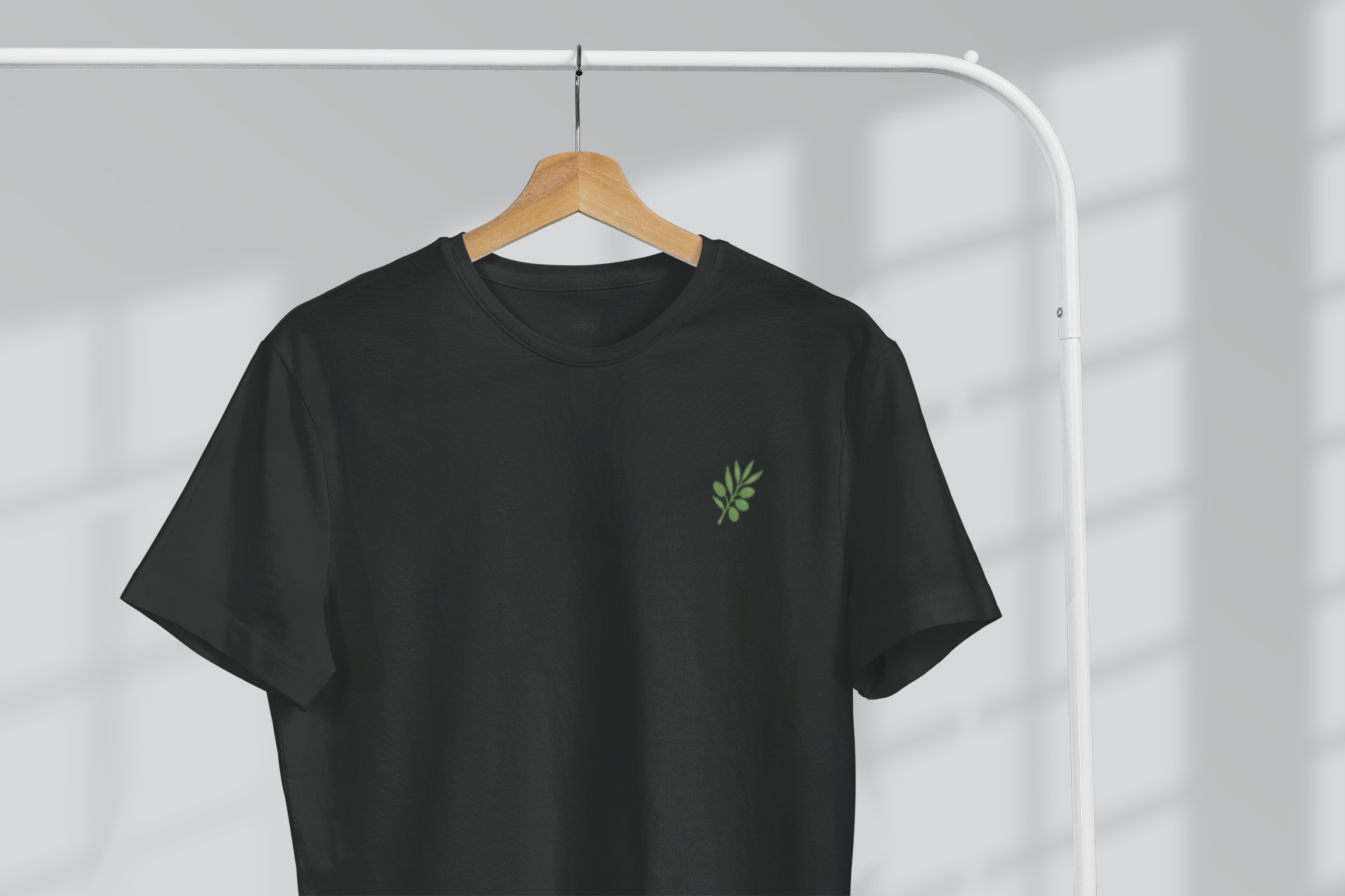 Black t-shirt with a green logo on a hanger against a white background