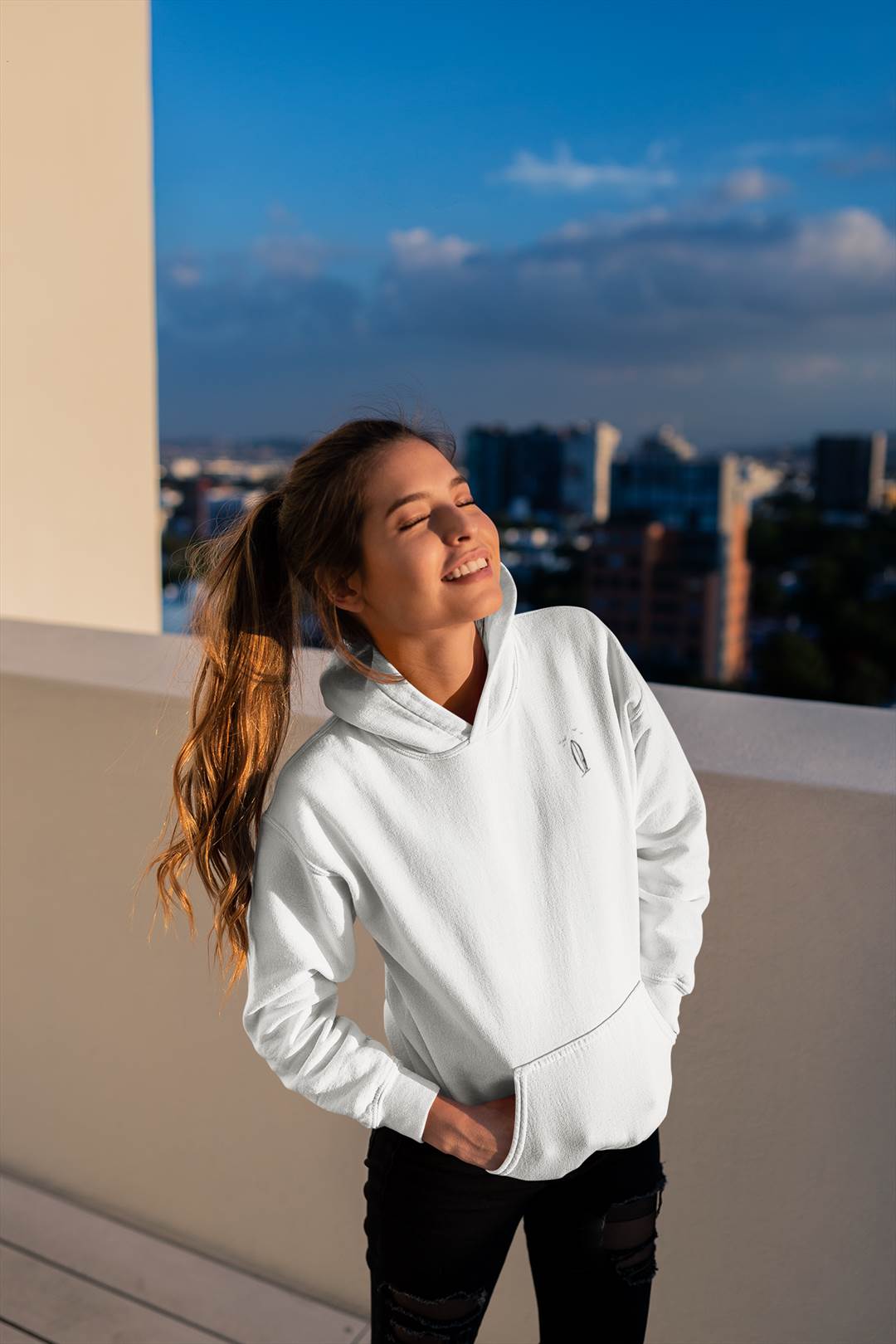 White Ericeira Surf Hoodie worn in golden sunlight. Ethically made, organic, and designed for comfort and minimalist surf style.